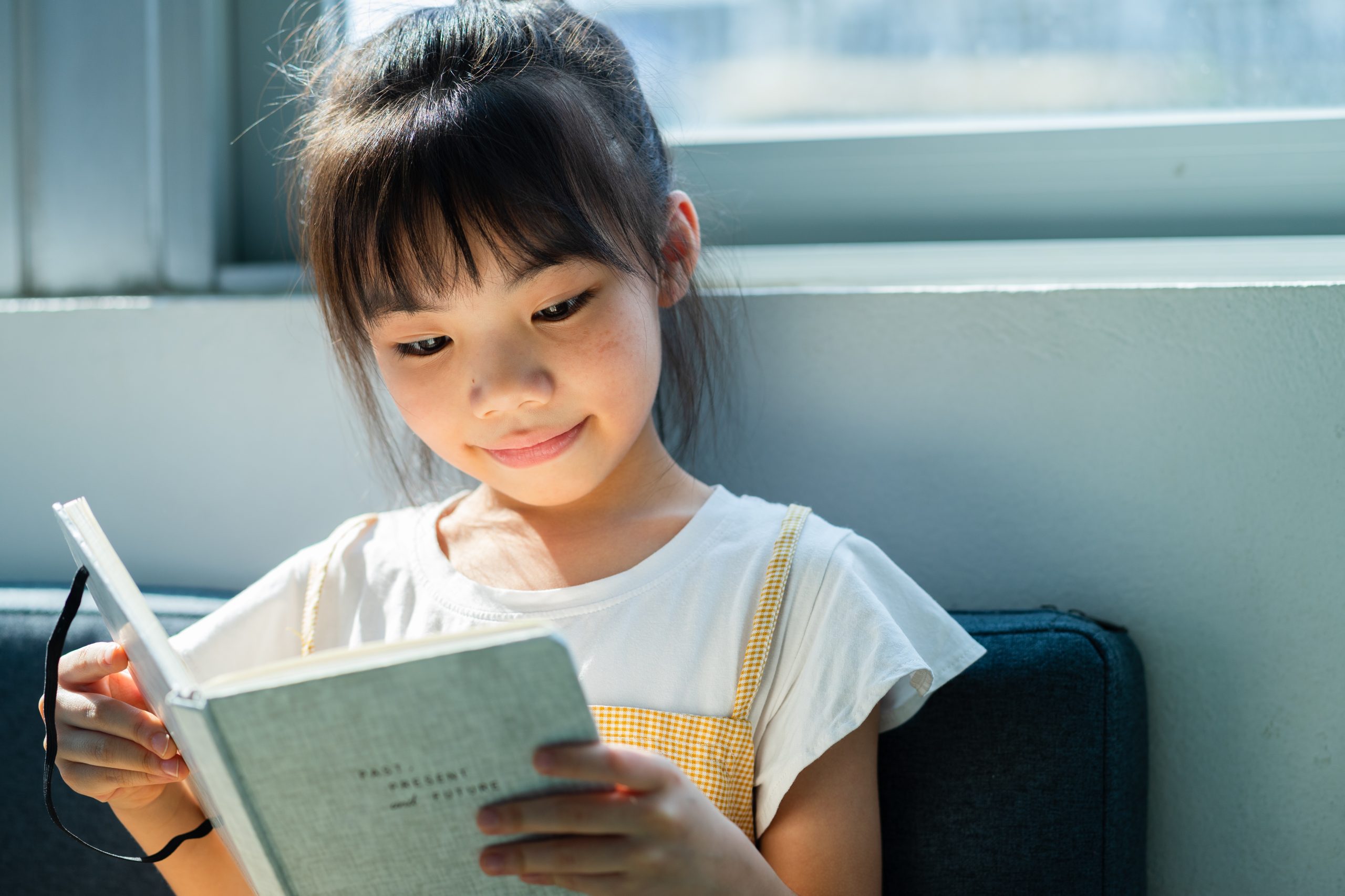 Asian,Child,Reading,Book,At,Home